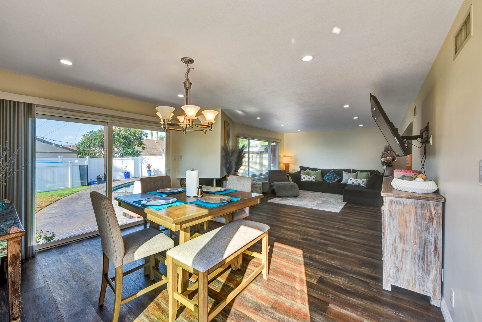 Open living and dining room with wood floors and sliding glass doors to the pool at 1300 Rutledge Place